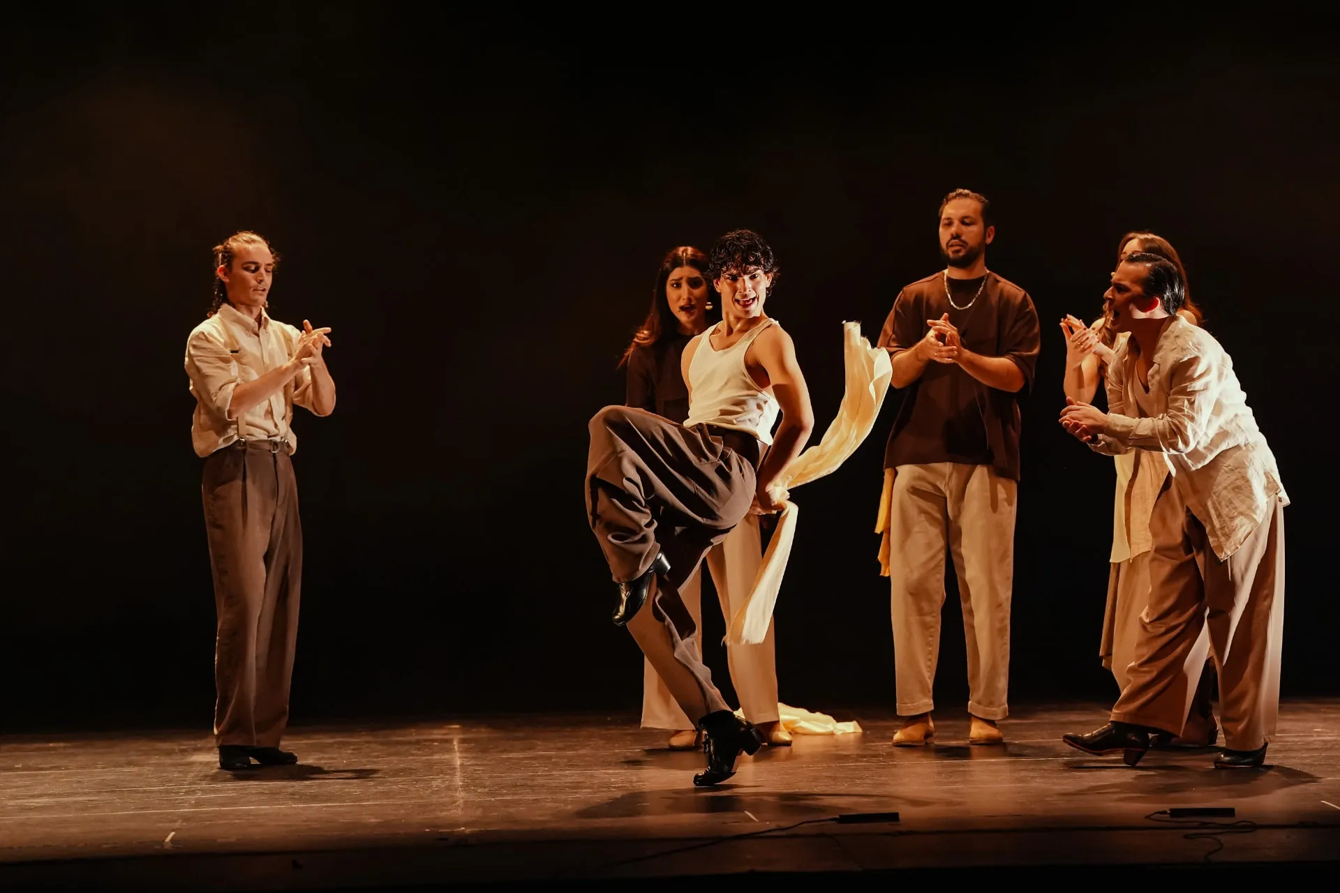 Bailaor con pañuelo rodeado por el cuadro flamenco