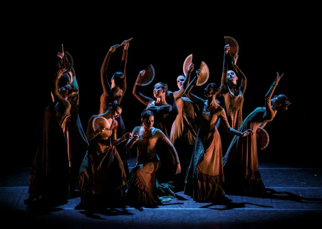 Bailarinas con abanico en escena oscura